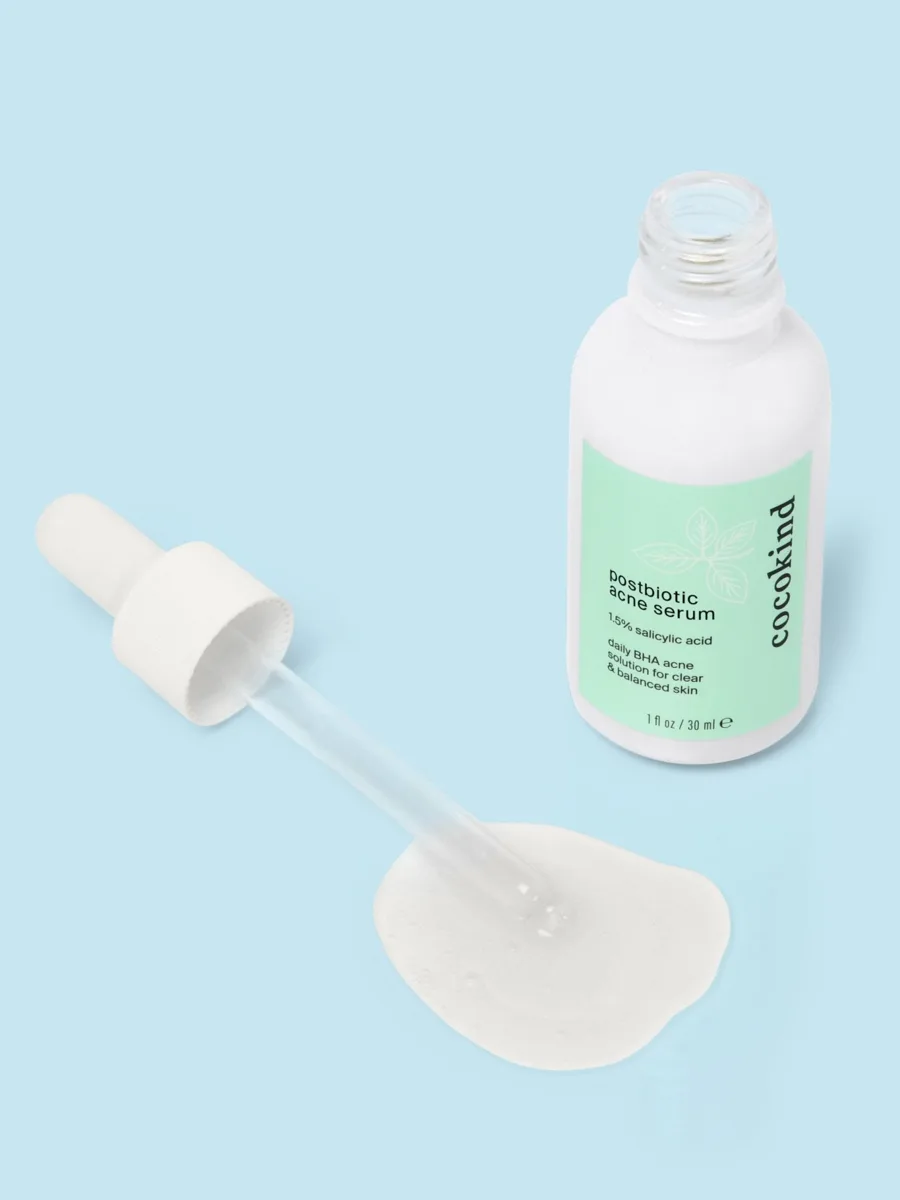 Cocokind Postbiotic Acne Serum in white-coated glass dropper bottle with minimalist branding