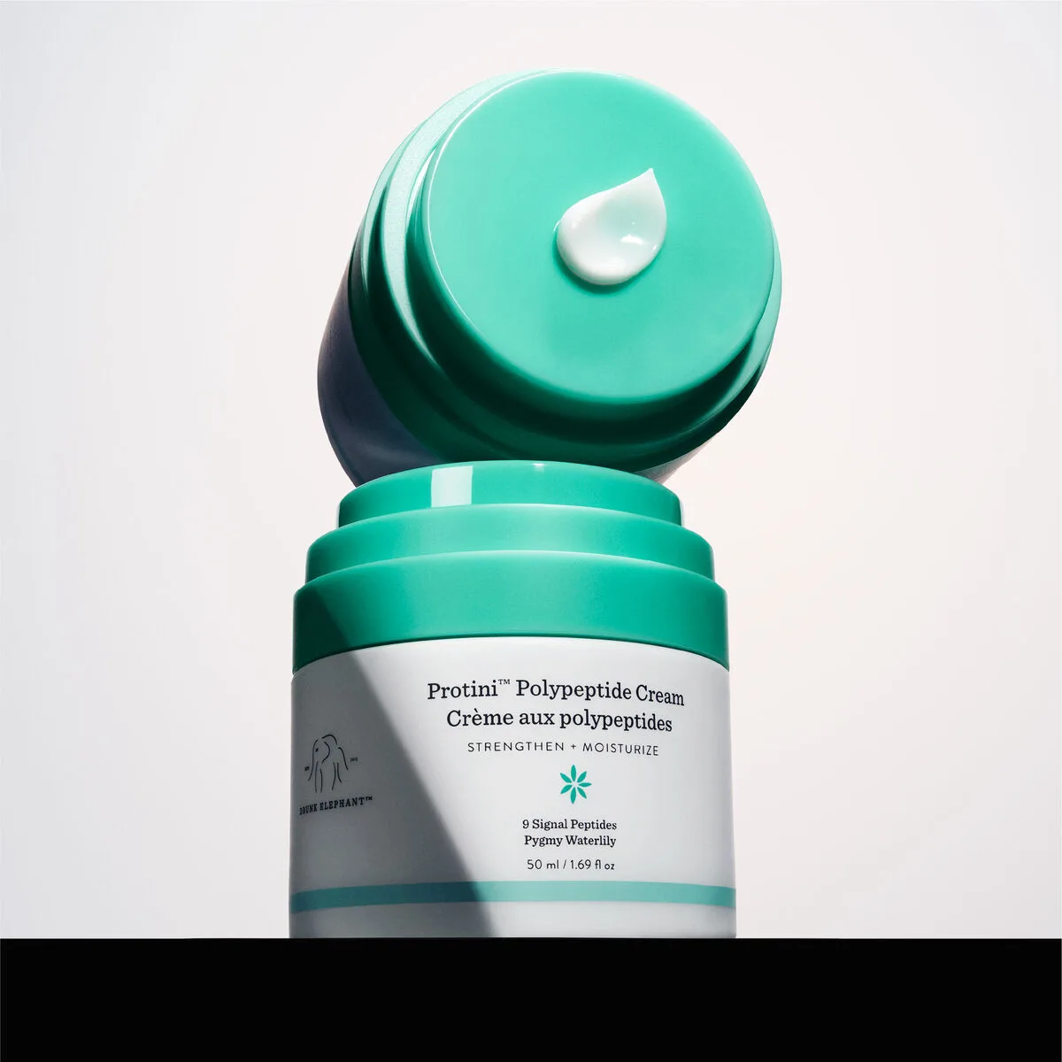 Drunk Elephant Protini Polypeptide Firming Refillable Moisturizer jar with signature multicolor stripe design
