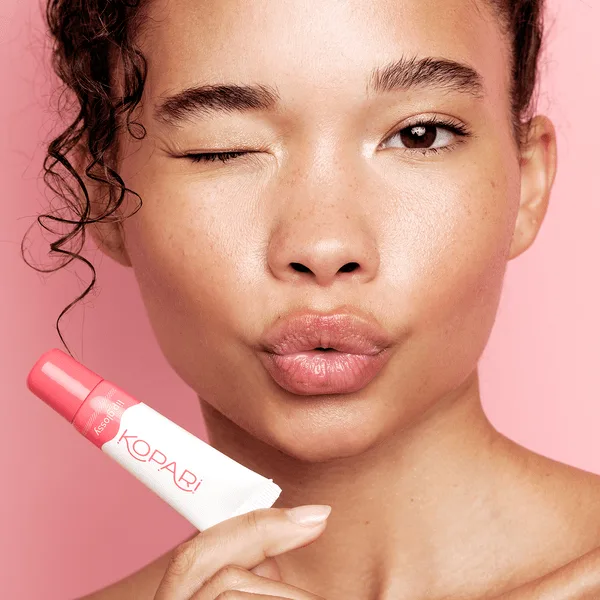 Kopari Coconut Lip Glossy clear lip gloss tube with white tropical-inspired packaging